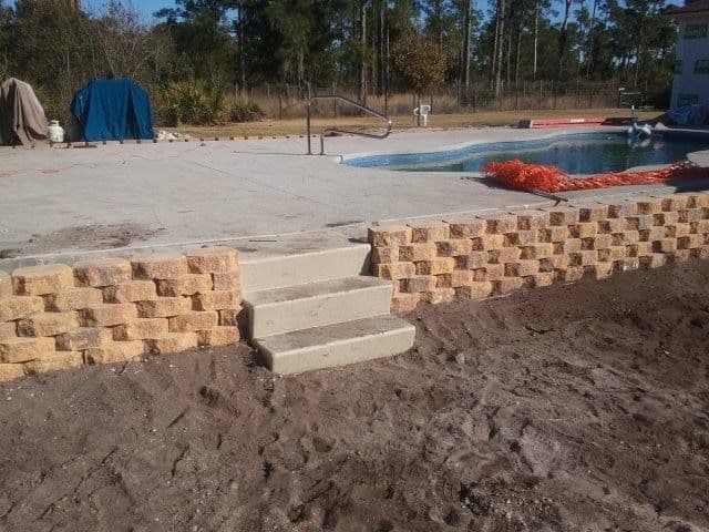 Retaining wall and steps under construction around a pool